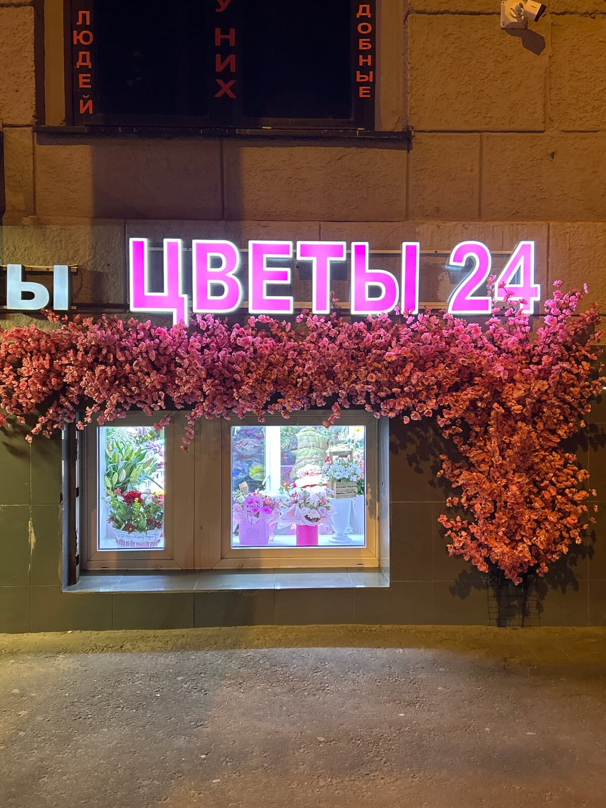 Неоновая вывеска «Цветы 24» над витриной, осеннее оформление фасада